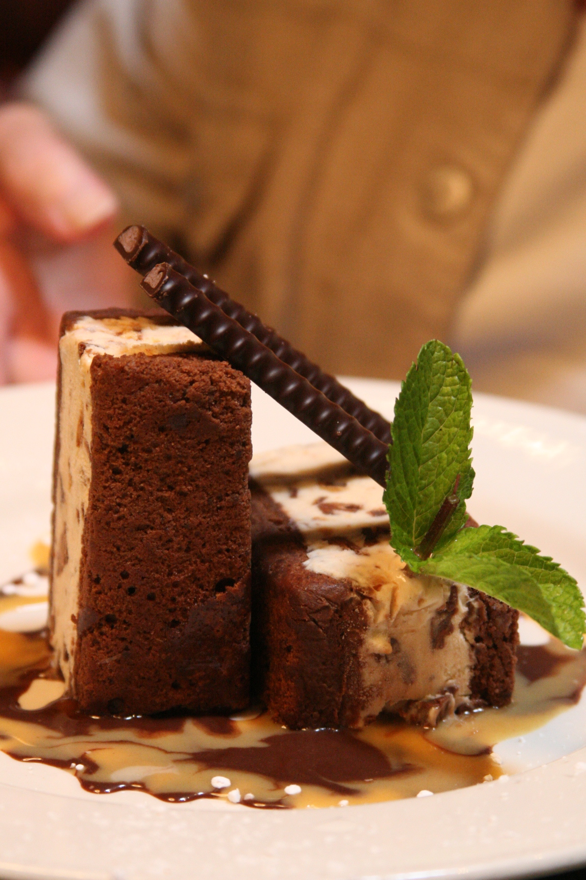 Chocolate peanut butter ice cream sandwhich served between chocolate fudge brownie cake